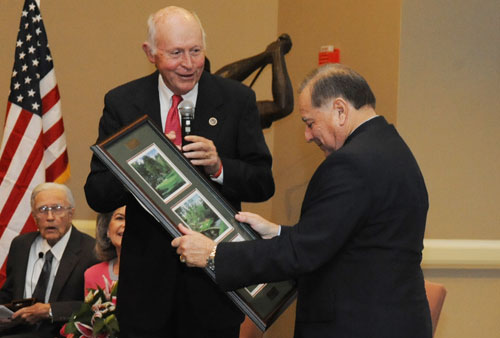Honoree retired Army Lt. Col. Alfred Rascon receives a framed collection of images from the Augusta National Golf Club.